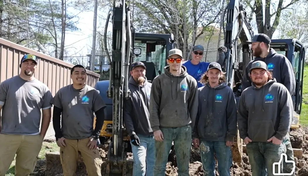 JLB crew team photo with excavators in background serving Ames, IA