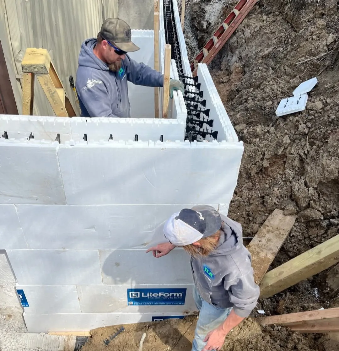Two-person JLB crew repairing foundation at Oak Grove residential project