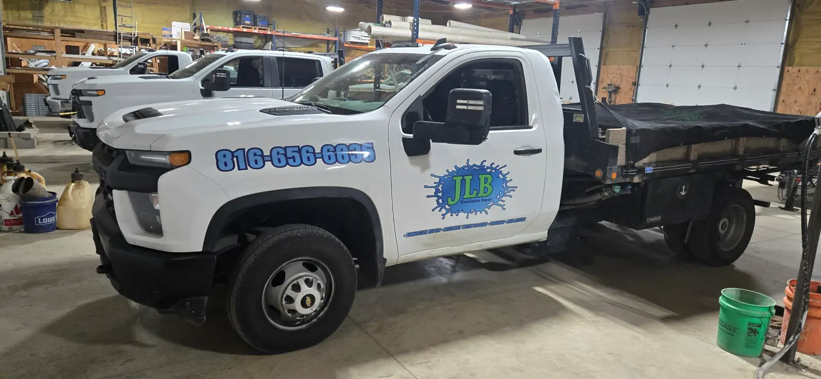 Rows of JLB branded service trucks lined up inside company warehouse
