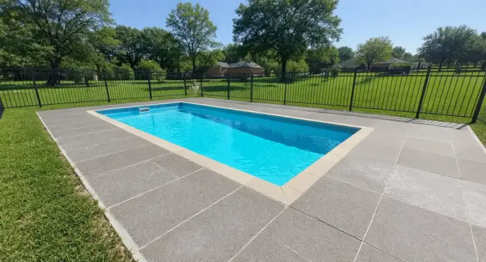 Broom-finished concrete pool deck around a fiberglass pool — pool decks by JLB in Clive, Iowa