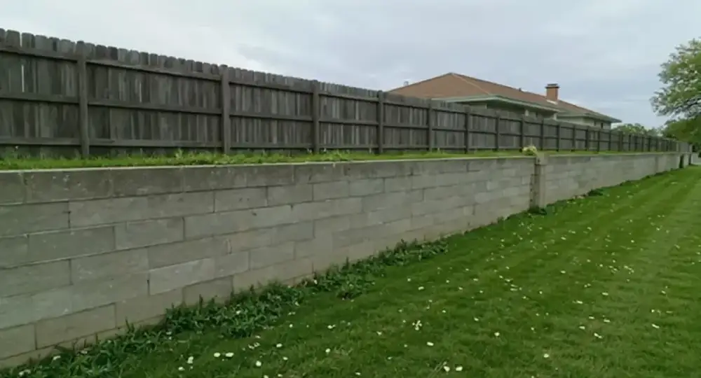 Long concrete retaining wall bordering a yard — retaining walls by JLB in Ankeny, Iowa