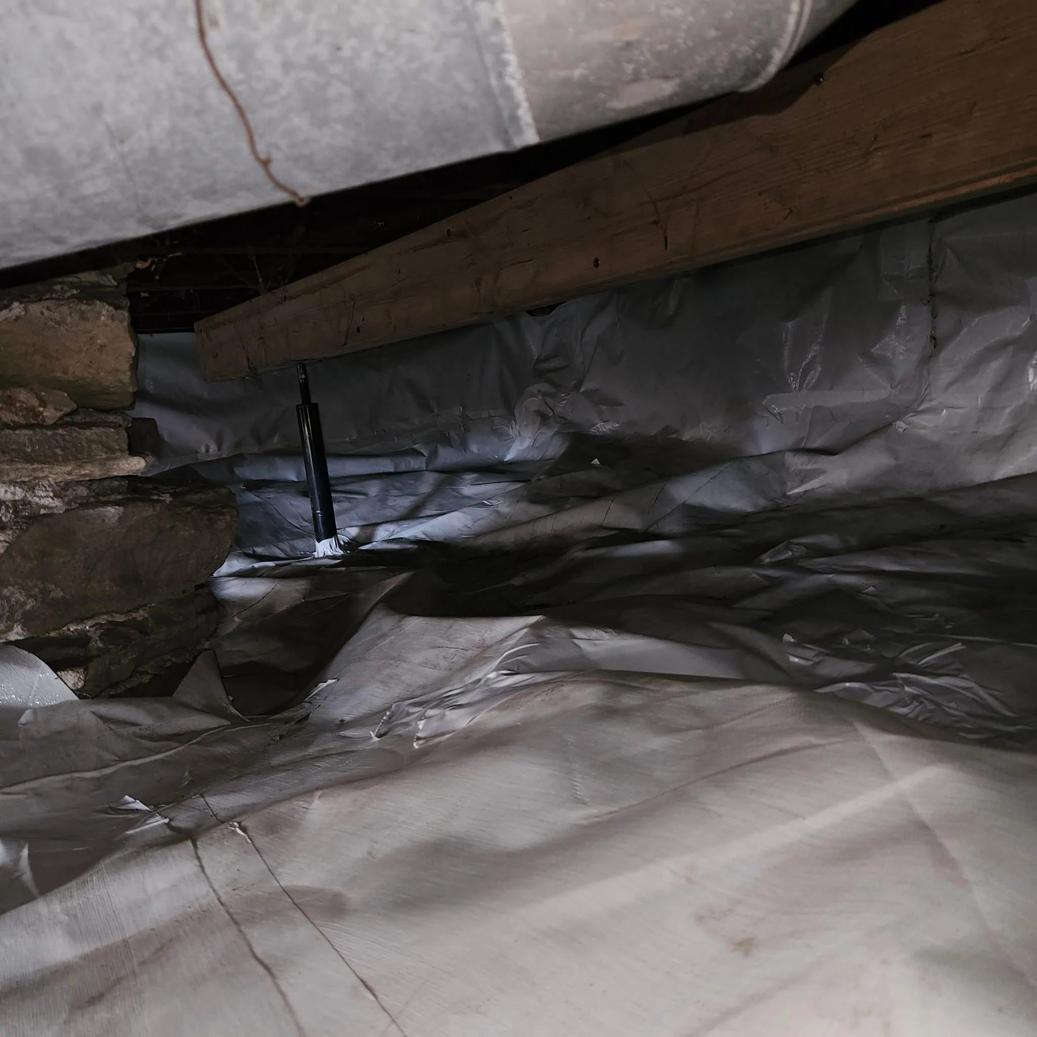 Vapor barrier liner covering crawlspace floor and walls in a Lenexa home