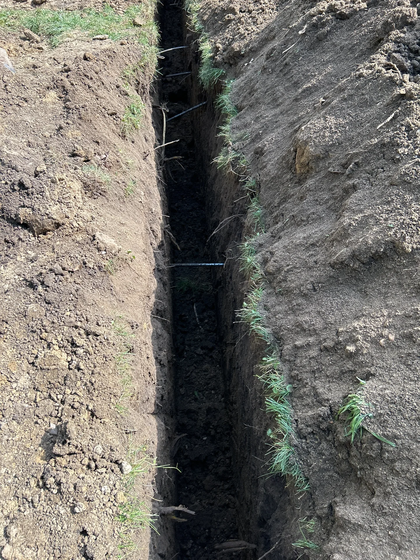 Foundation trench dug through heavy clay to install wall anchors in Conrad, IA