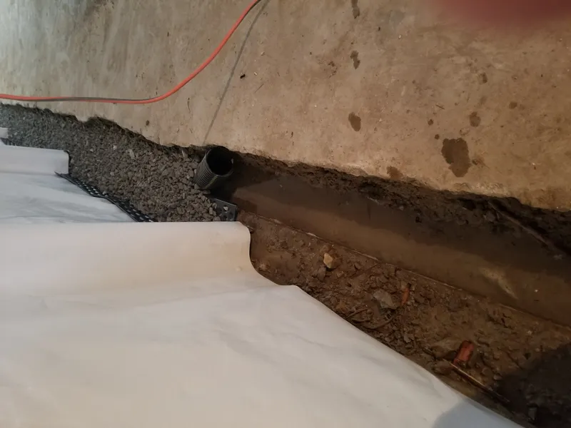 Drain tile pipe and gravel bed in a basement waterproofing system in Overland Park, KS