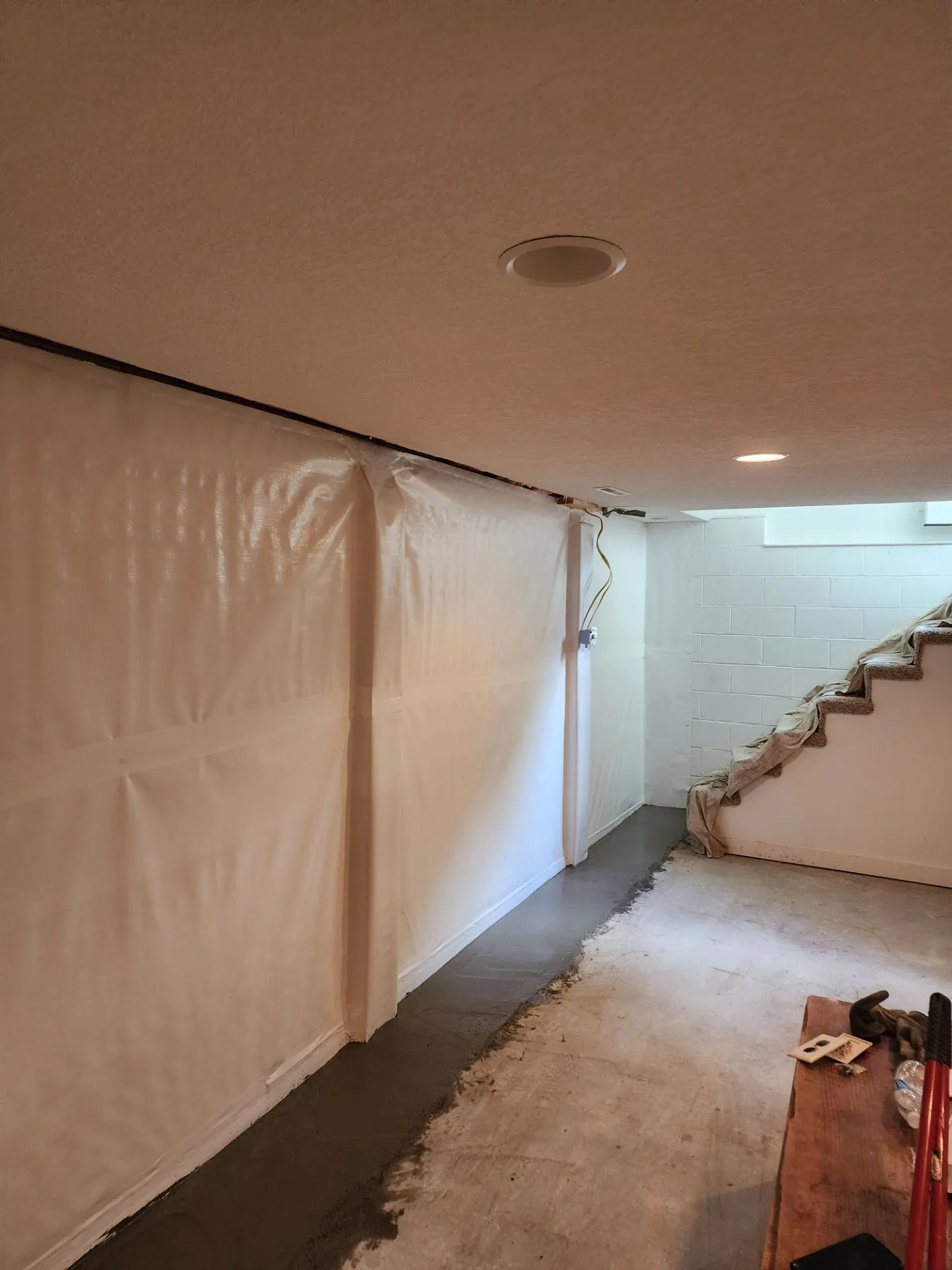 Waterproofing membrane on basement foundation wall adjacent to interior stairs in Kansas City, MO