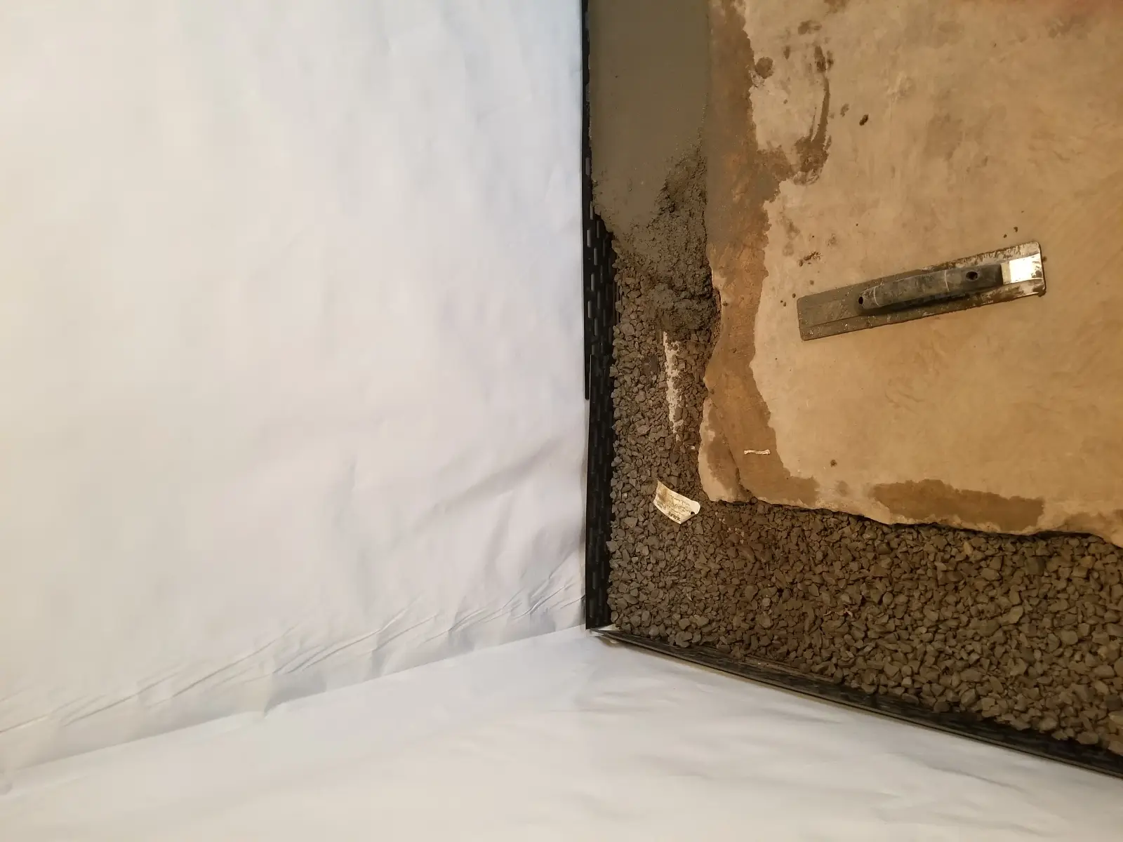 1970s Poured concrete basement basement in Lenexa — interior drain tile and vapor barrier installed by JLB